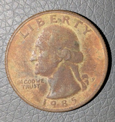 1985 quarter clipped planchet error showing curved missing section along the coin's edge