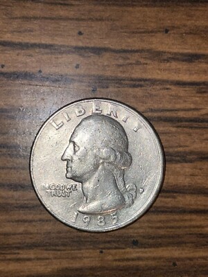 1985 quarter struck-through grease error showing missing or mushy design area where lubricant filled the die cavity