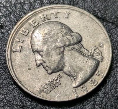 1985 quarter broadstrike error showing expanded diameter and weak rim compared to normal quarter